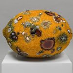 Sculpture of a lemon with molding patterns on it made of gems and rocks