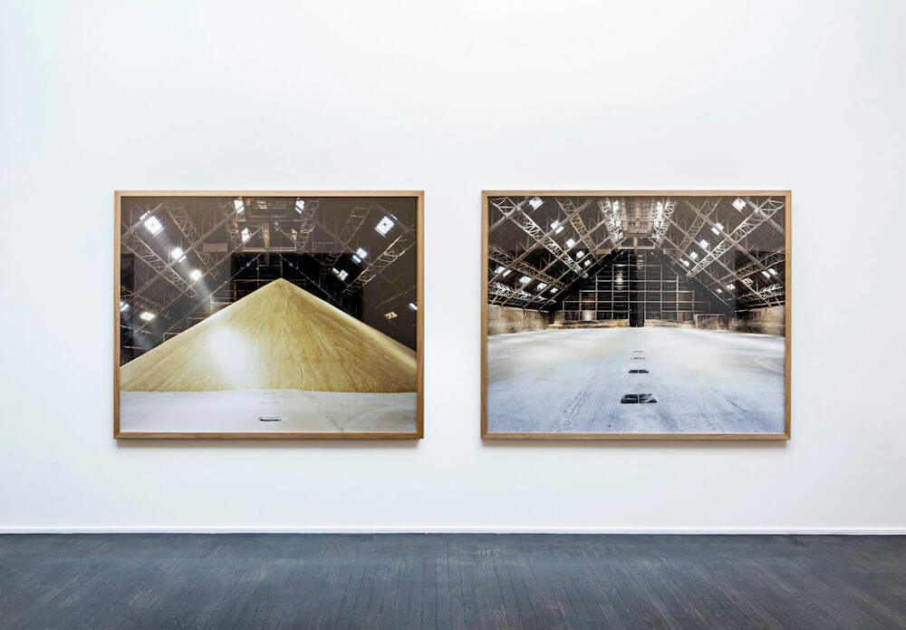 Two framed photos of an interior space with and without a large yellow pile